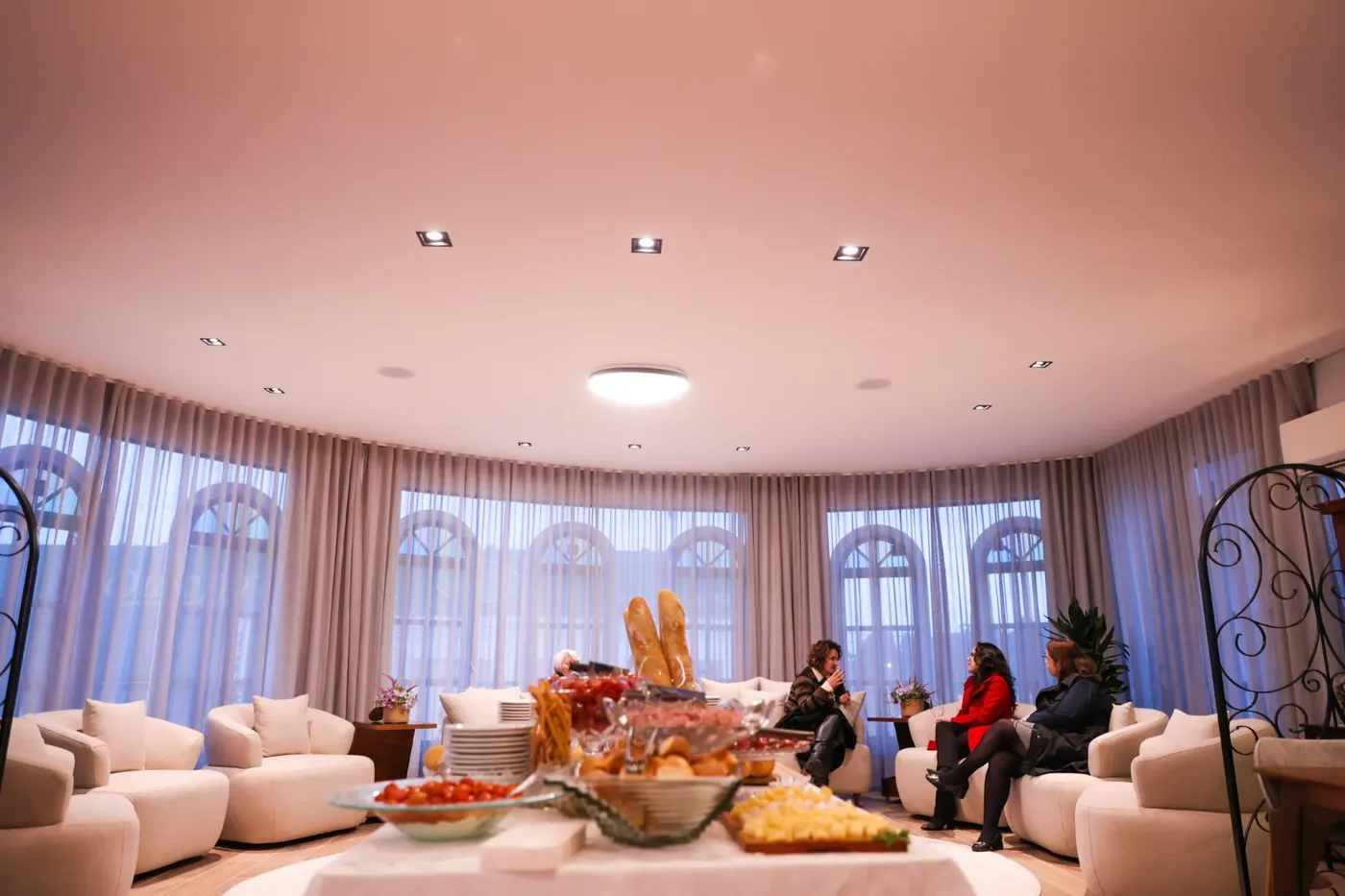 Salão de degustação da loja, com mesa posta e visitantes sentados nas poltronas