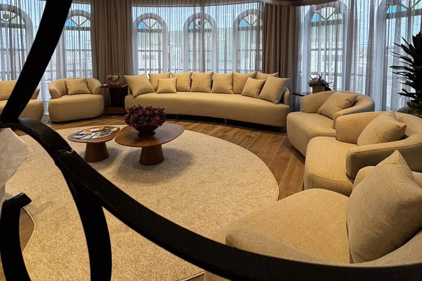 Sala de estar da loja, com poltronas em círculo e janelas em arco